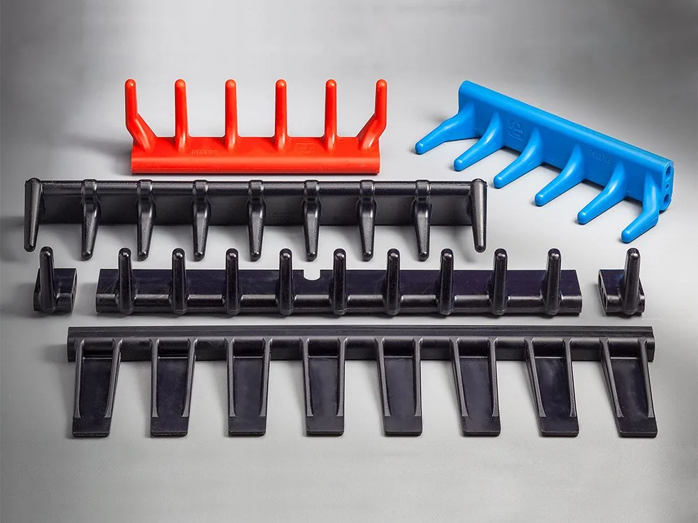 Gieß-Elastomer-Bauteile für die Agrartechnik neben metallischen Gegenstücken