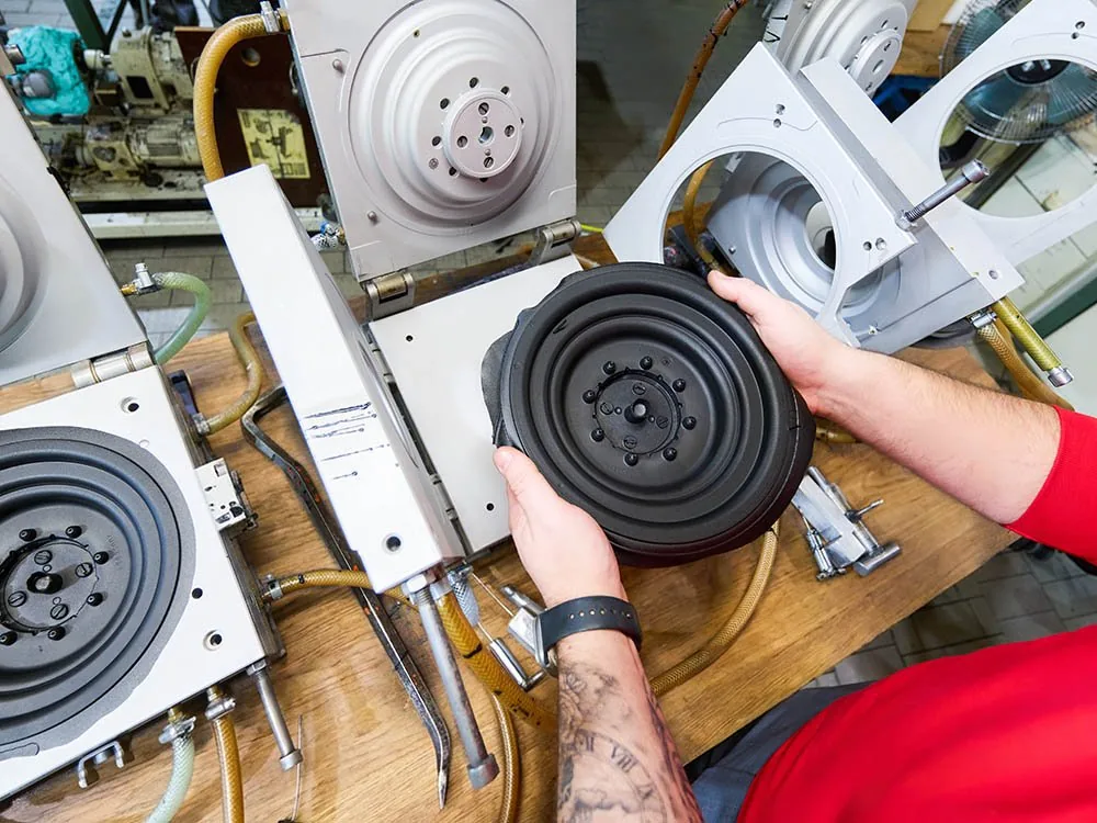 Mitarbeiter hält ein rundes dämpfendes Elastomer-Schaum-Bauteil in der Hand