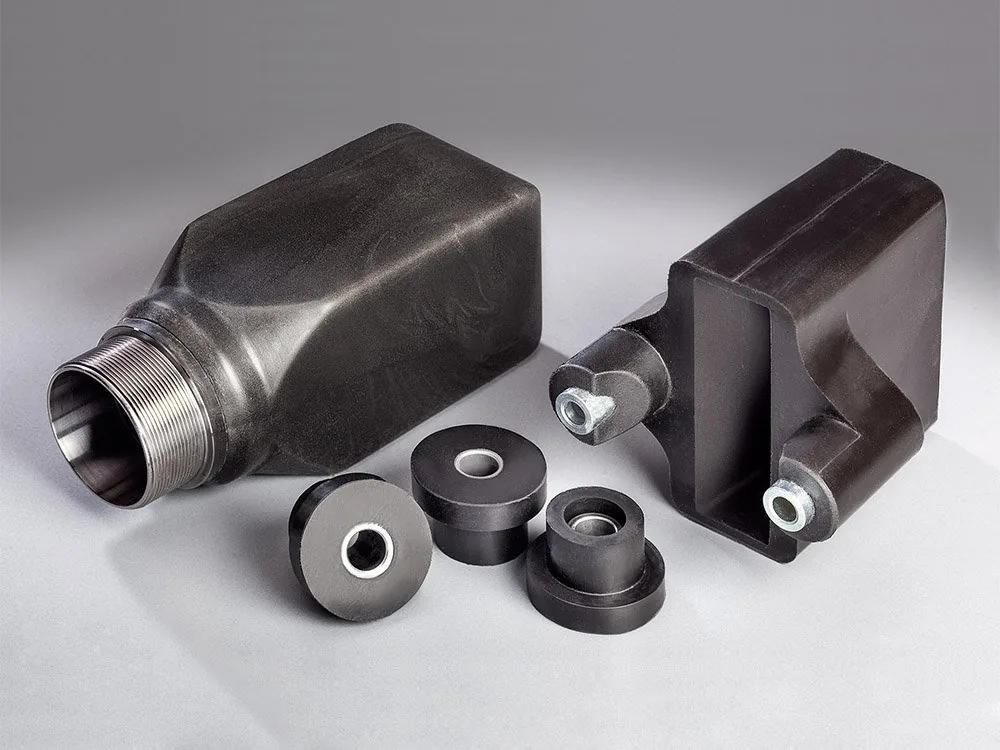 Schwarze Elastomer-Schaum-Formteile mit eingelassenen Metallbuchsen